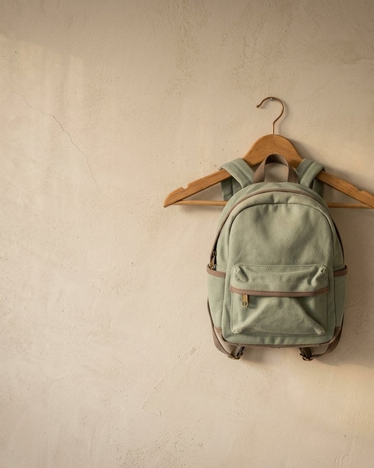 Mochila infantil colgada de una percha de madera